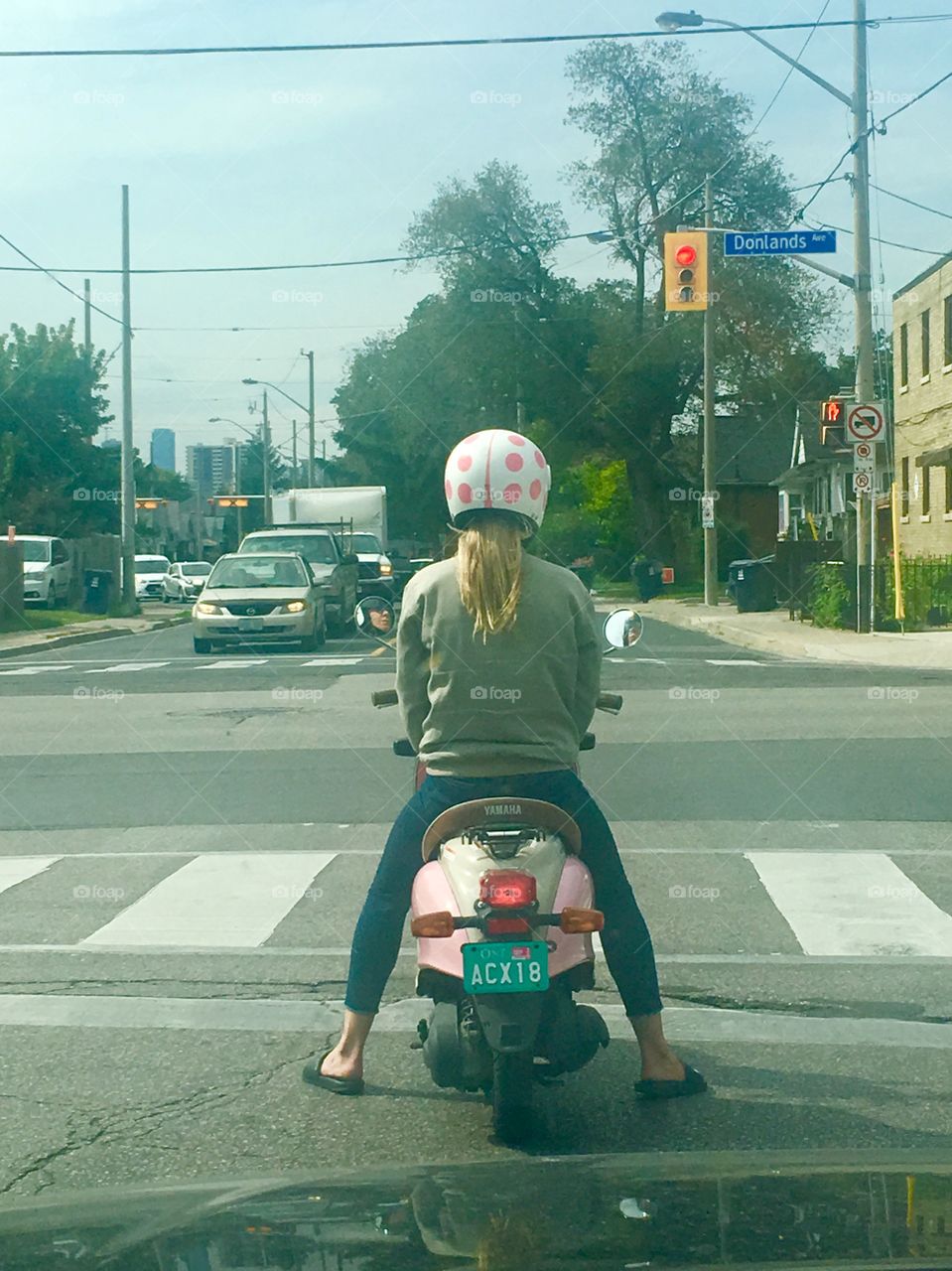 Woman Riding Through the City: Pink Moped and Pink Polka Dotted Helmet 