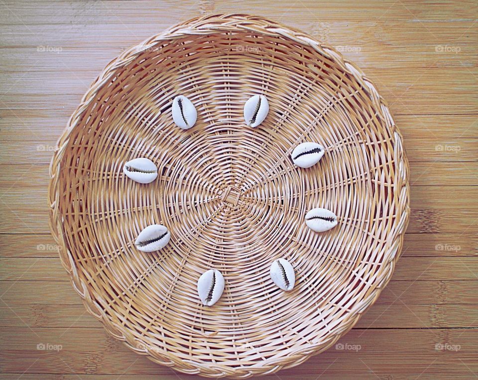 Shells on wicker on a wooden table 