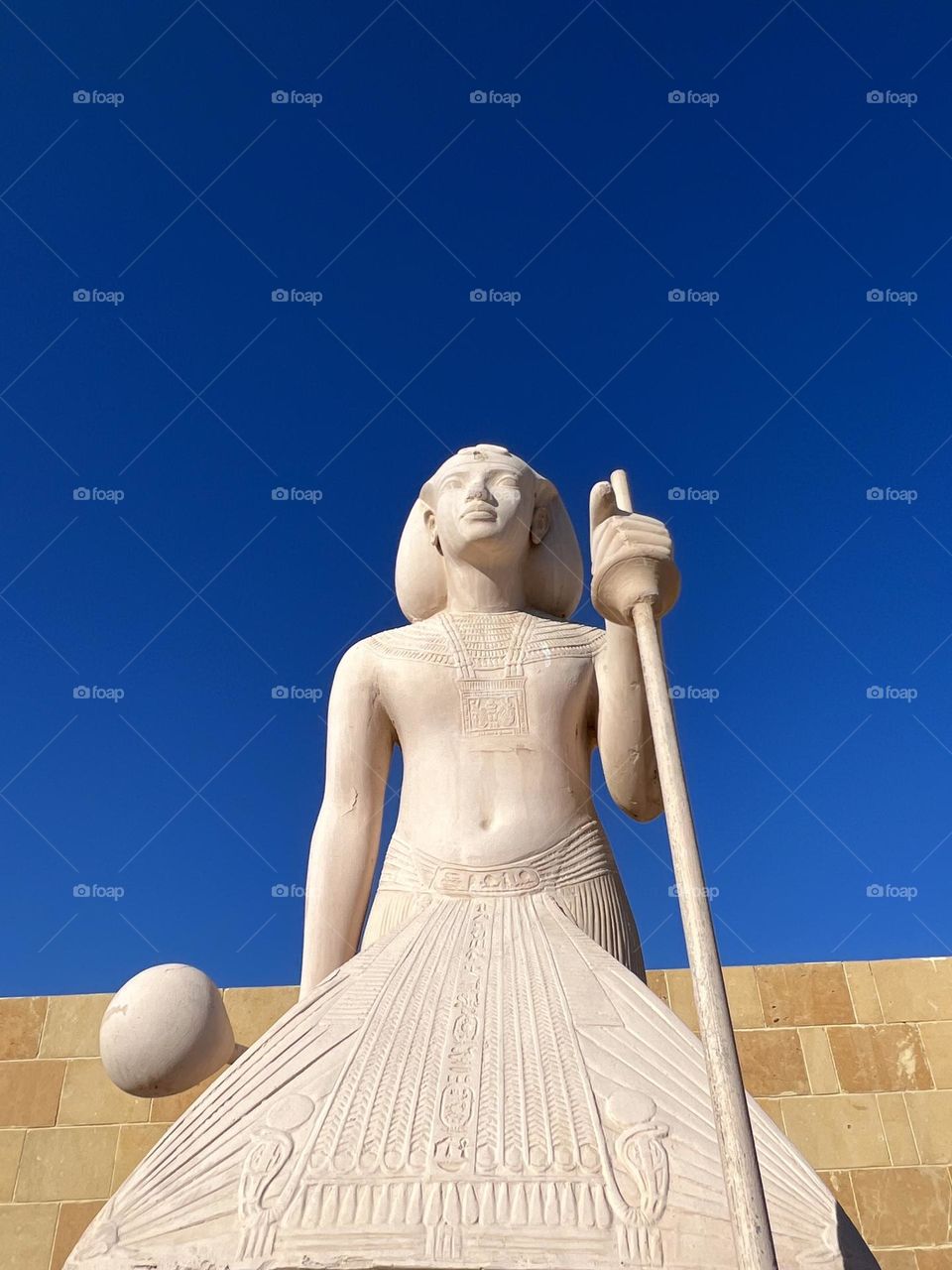 From the ground up. Egypt. Blue sky and Egyptian pharaoh sculpture 