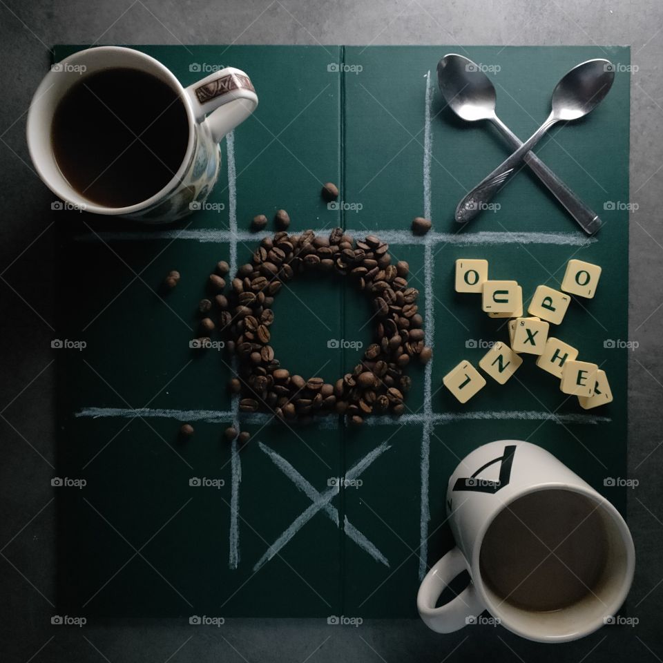 My favourite coffee mugs playing a creative game of noughts and crosses with coffee beans, spoons and even scrabble pieces.