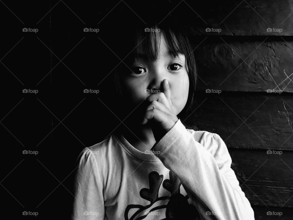 Be quiet,  just watch and learn. A black and white portrait of a girl child learning the tricks and trade of life.