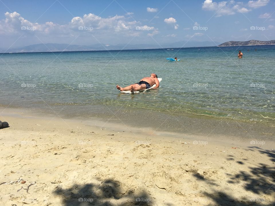 Man on sunbed in the water enjoying the sun