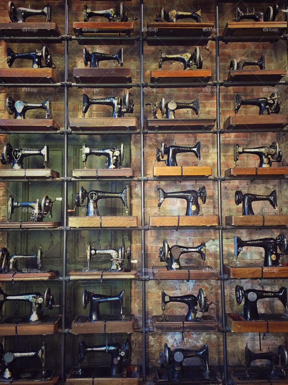 Wall of old fashioned sewing machines 
