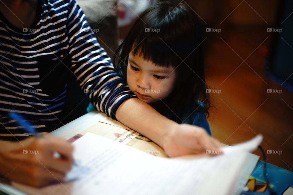 Mother is helping her child doing home work