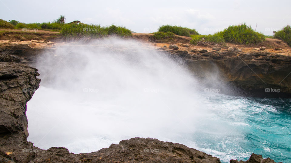 Waves crashing against the shore on the island of Nusa Lembongan, caught in a long exposure photograph