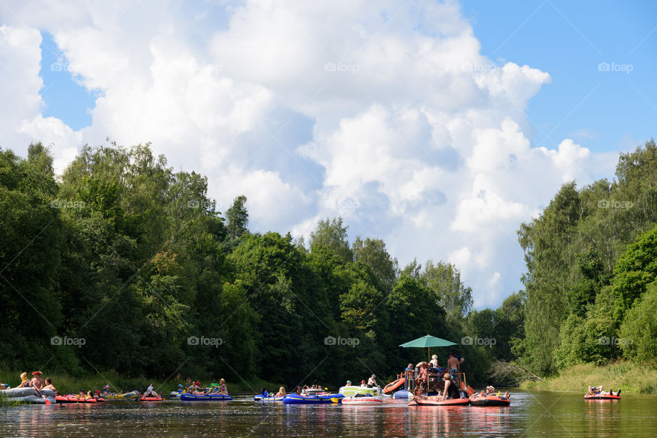 Helsinki, Finland – July 30, 2016: Unidentified people drafting and tubing in Vantaanjoki river on rubber dinghies, rafts and other inflatable floating devices at yearly Kaljakellunta (Beer Floating) festival which occurs at the end of the July or beginning of the August. Festival which usually attracts more than hundreds of participants every year is a spontaneous gathering of people and there is no official organizer for the event.