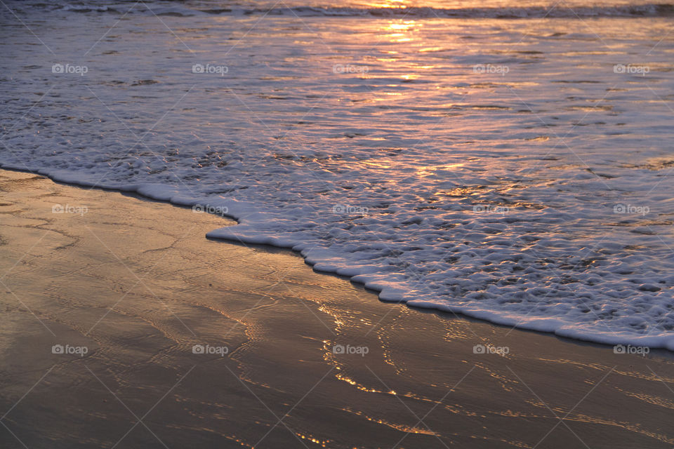 Reflection of sunrise on the beach.