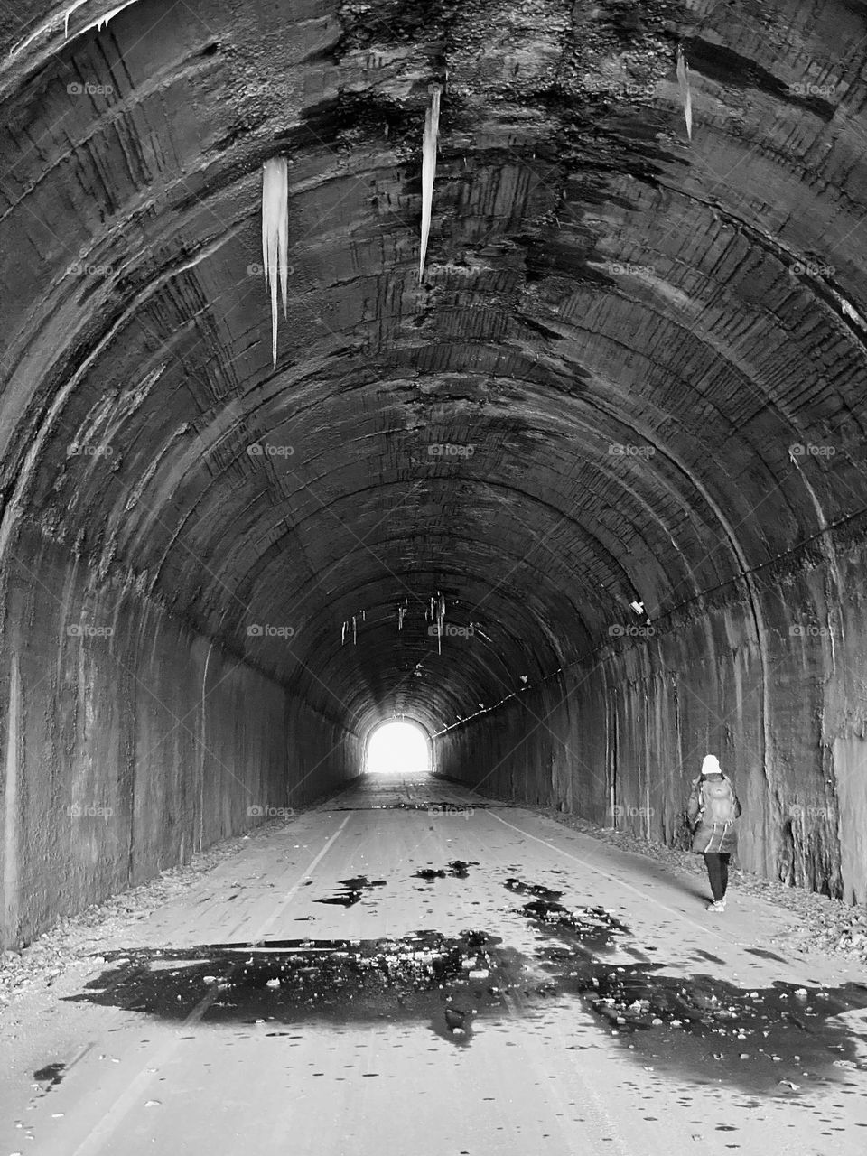 A person walking through the Borden Tunnel, part of the Great Allegheny Passage trail 