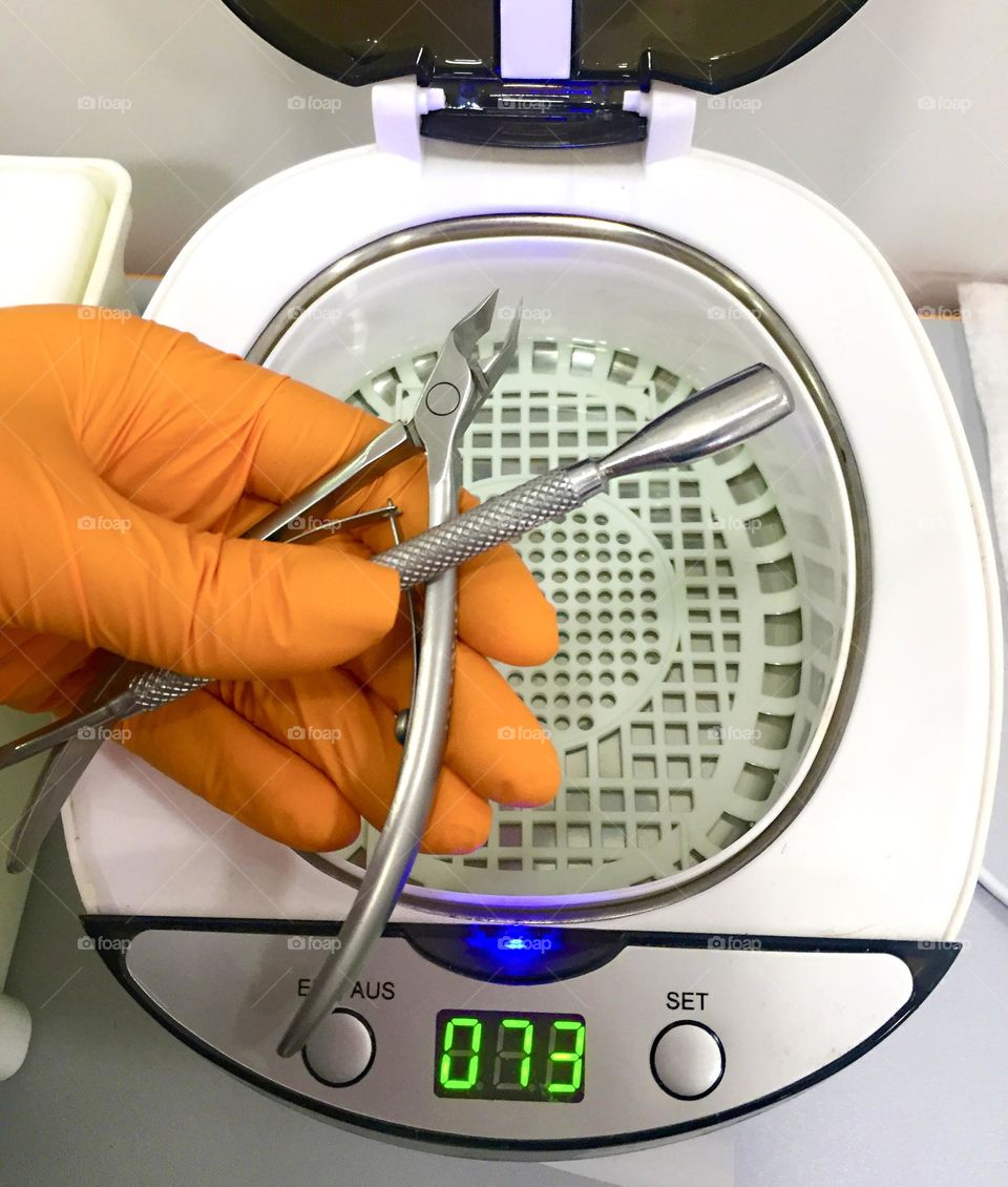 Sterilization of manicure instruments in an ultrasonic bath.
