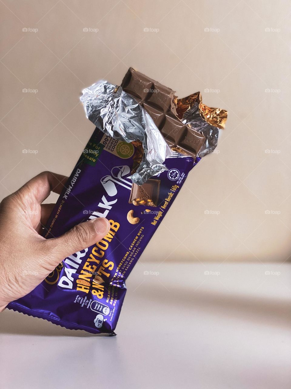 Holding a delicious cadbury chocolate bar.