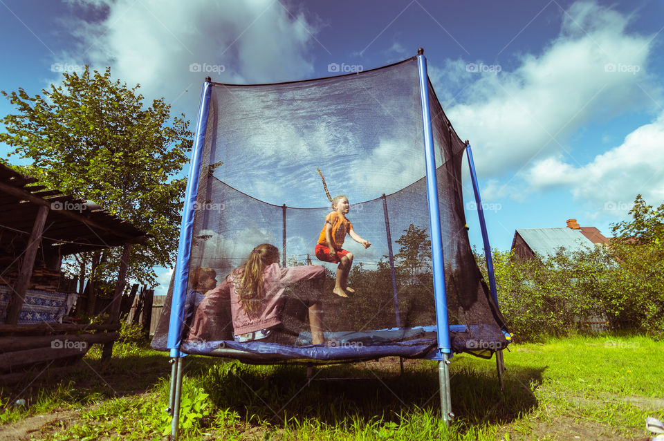 Kids are jumping on trampoline