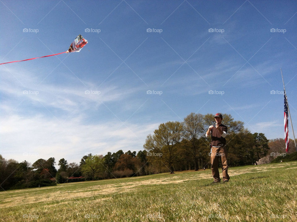 A daddy showing his son how to  fly a kite