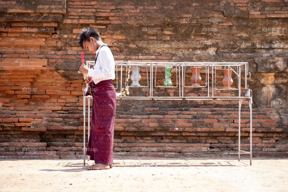 Boy try to light the incense sticks 