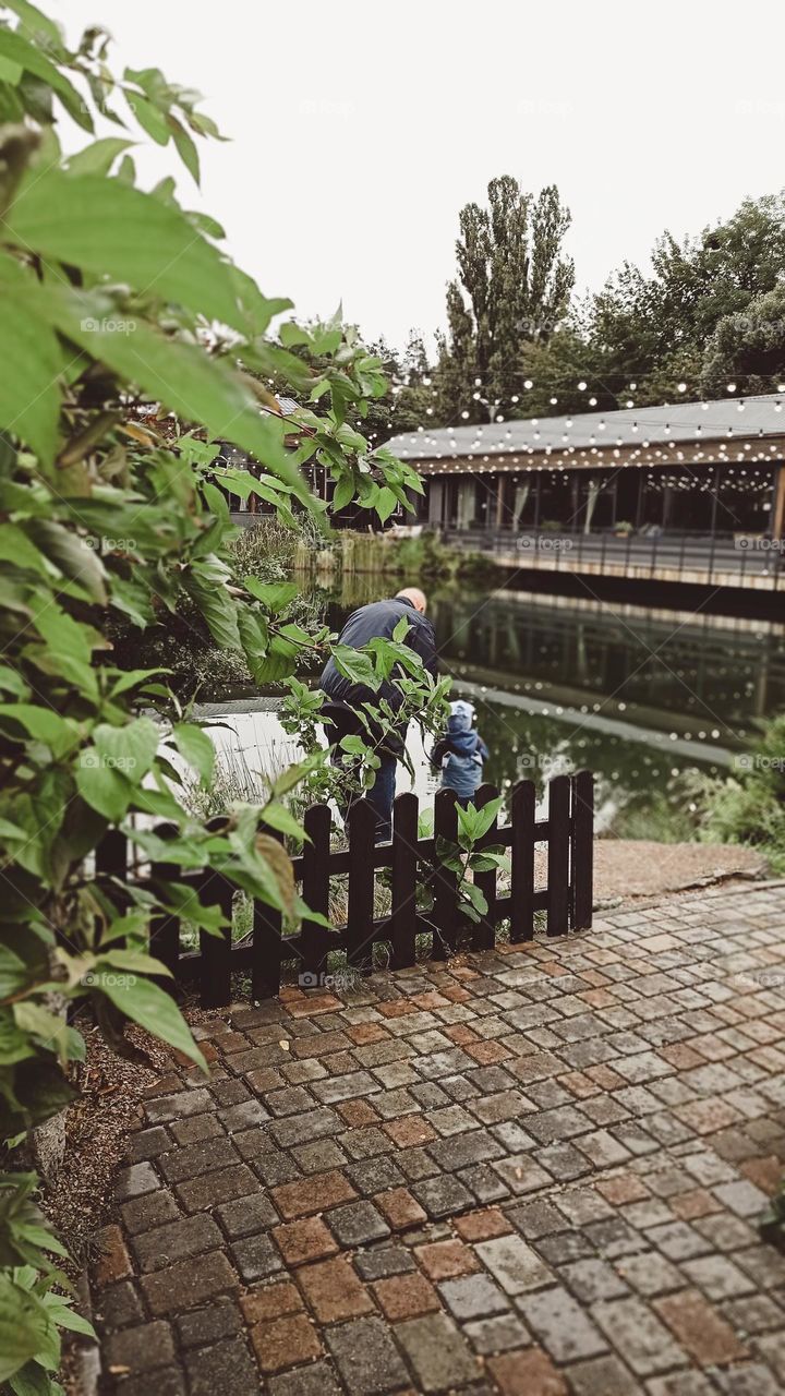 father and son feeding the fish