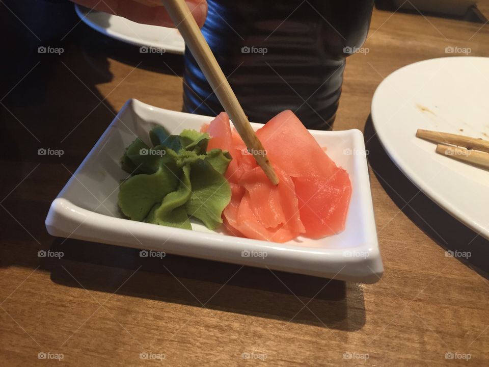 Ginger and wasabi at sushi with chopsticks