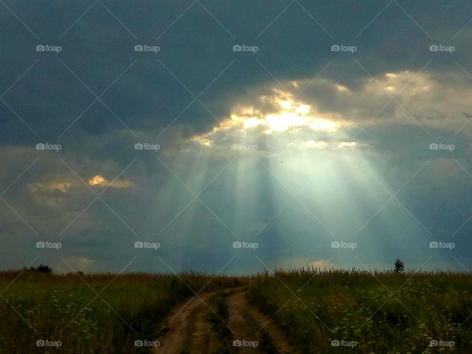 лучи солнца сквозь грозовые тучи