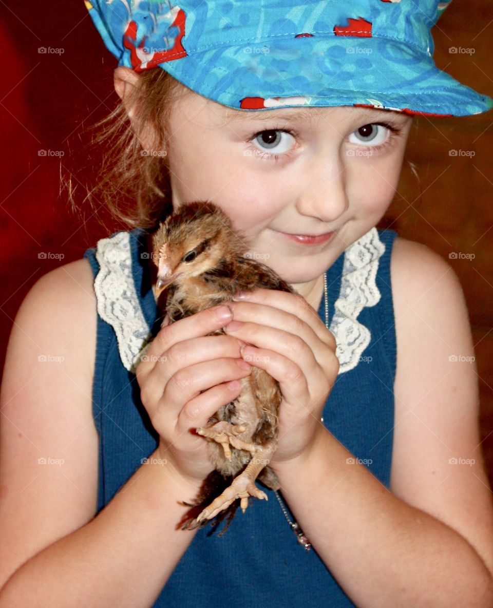 Girl tenderly holding a fuzzy chick - adorable 