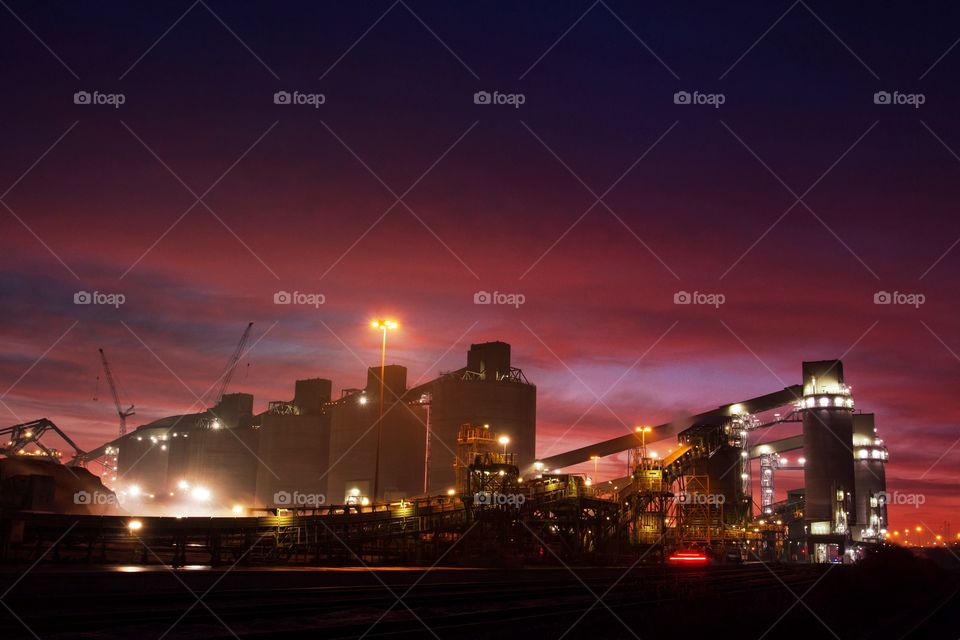 Early morning sunset over an industrial plant. Busy industrial landscape at night with colour in the sky.