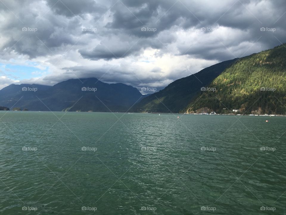 View of mountain and lake against storm cloud
