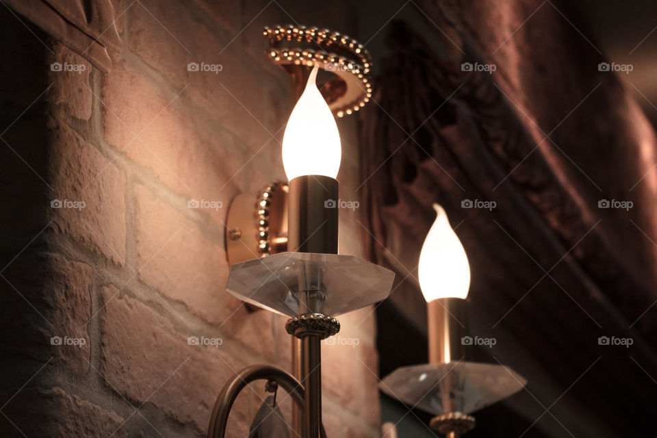 light bulbs in the form of candles hanging on a brick wall