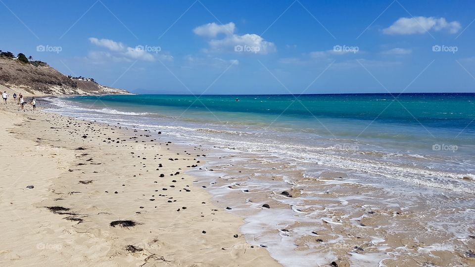 Beautiful beach in Fuerteventura in sunny weather , Canary Islands Spain -  semester strand grönt blått hav , Kanarieöarna i Spanien 