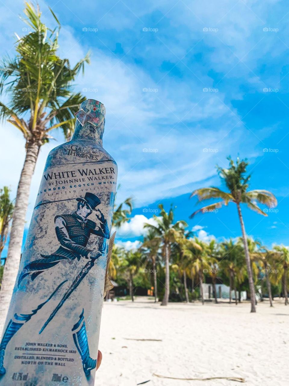 A bottle of Johnny Walker which is known as the best alcoholic drink in the world. This photo using one of beaches in Bali as its background.