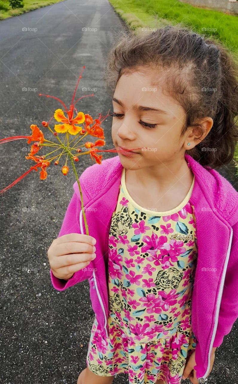 Child smells the scent of a beautiful flower. I love spring with its multicolored, fragrant and beautiful flowers.