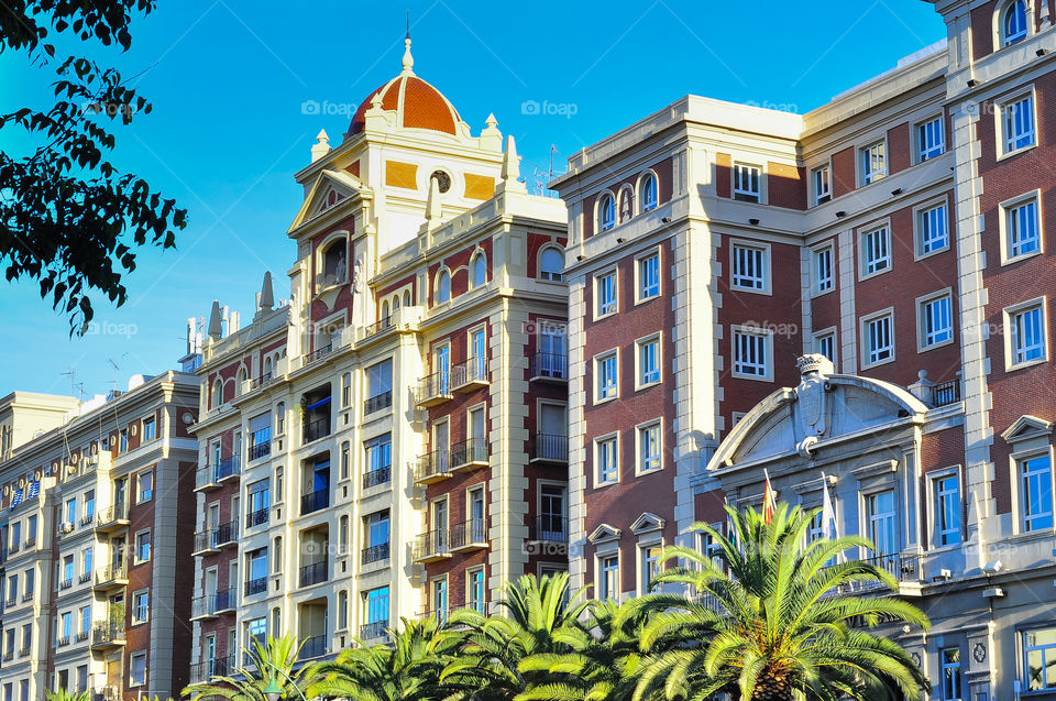 Beautiful building in Malaga with blue sky behind and few palms near 