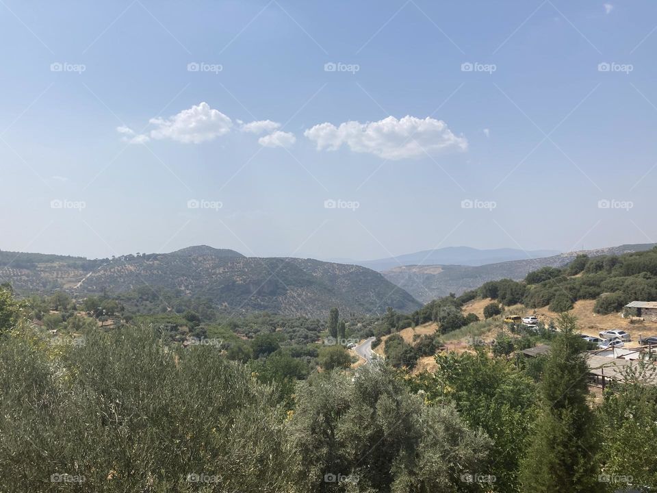 Greek village in Turkey. Blue sky and tall palm trees. Sunsets and sunny days. Summertime in Kusadasi. Vacation travel in Turkey . Summer view. Sunny day during vacation 