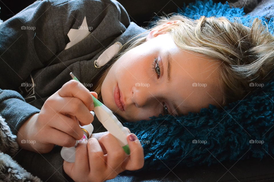 Sick girl with a fever thermometer