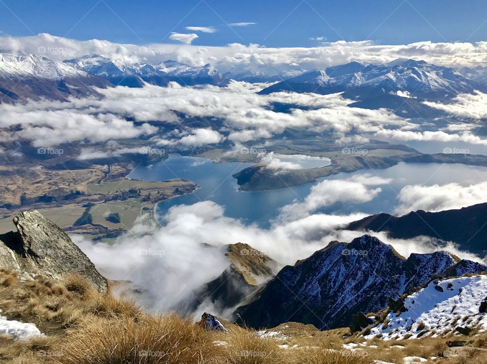 A view from above the clouds over lakes towards snow capped mountains, Wanaka New Zealand 
