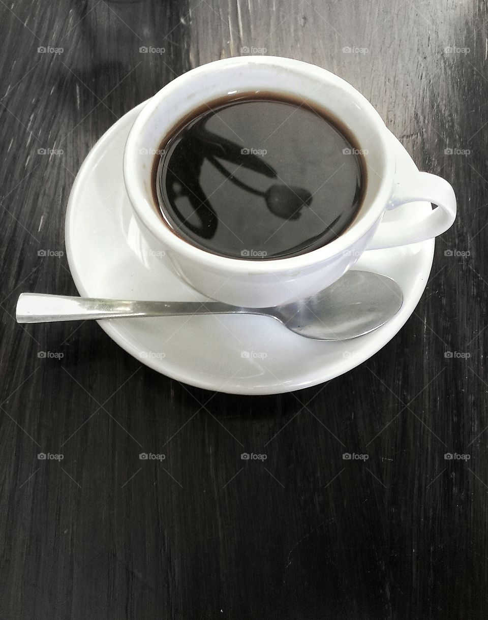 Reflection in a coffee cup. Tulip reflecting in the cup of black coffee.