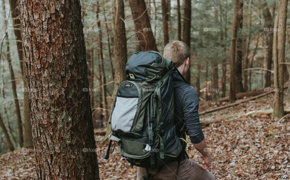 Man Walking Through Forest with Backpack