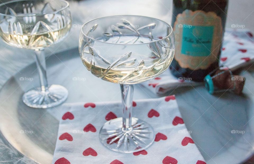 Vintage style Champagne Coupe Glass on a heart-patterned cloth napkin.