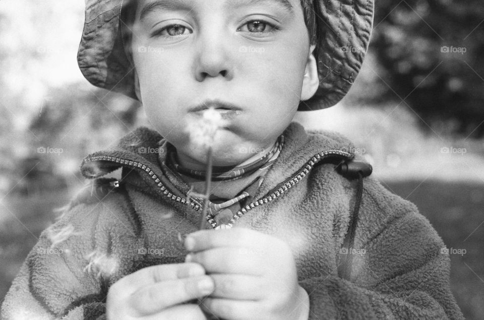 Boy blowing dandelion flower