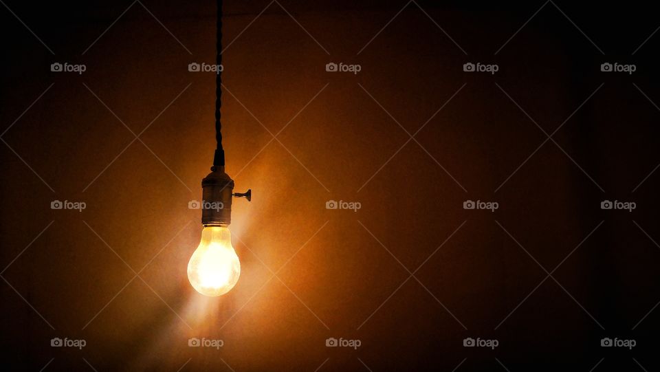 Light bulb hanging in a room. Thinking