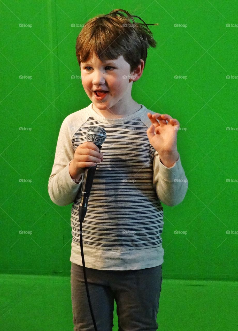 Little Boy Singing Into A Microphone