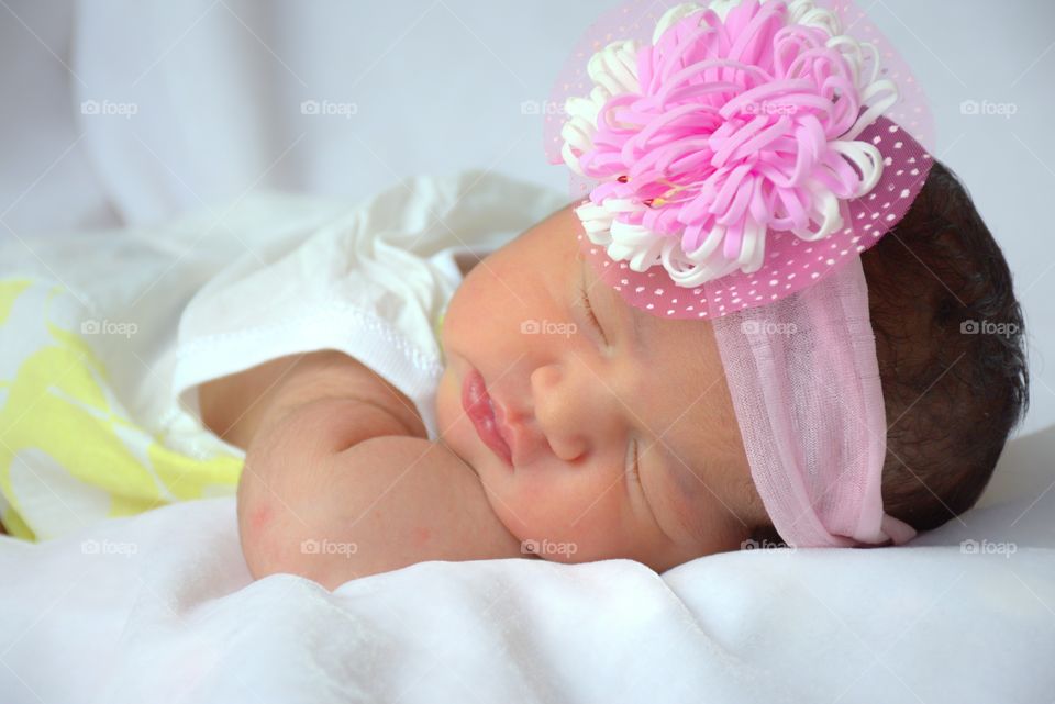 Cute baby on bed with pink hairband
