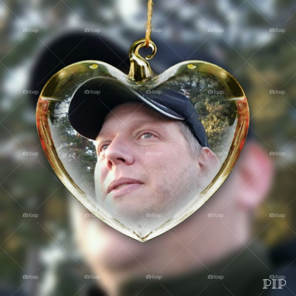 Reflection of man's face on heart shape pendant