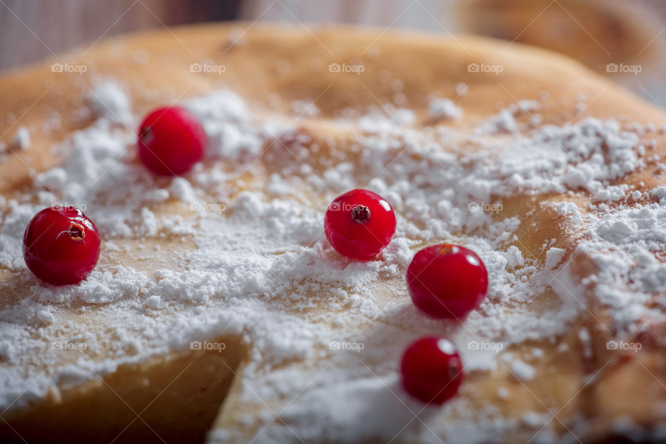 Cheesecake with cranberries and sugar on wooden background 