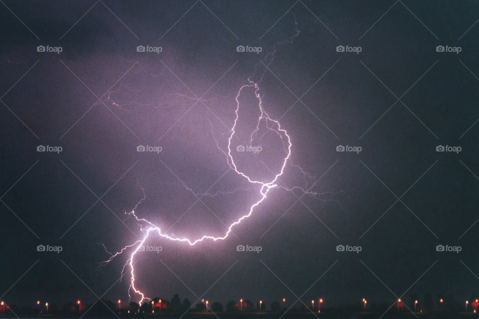 A powerful lightning bolt strikes to the earth from a severe thunderstorm in The Netherlands