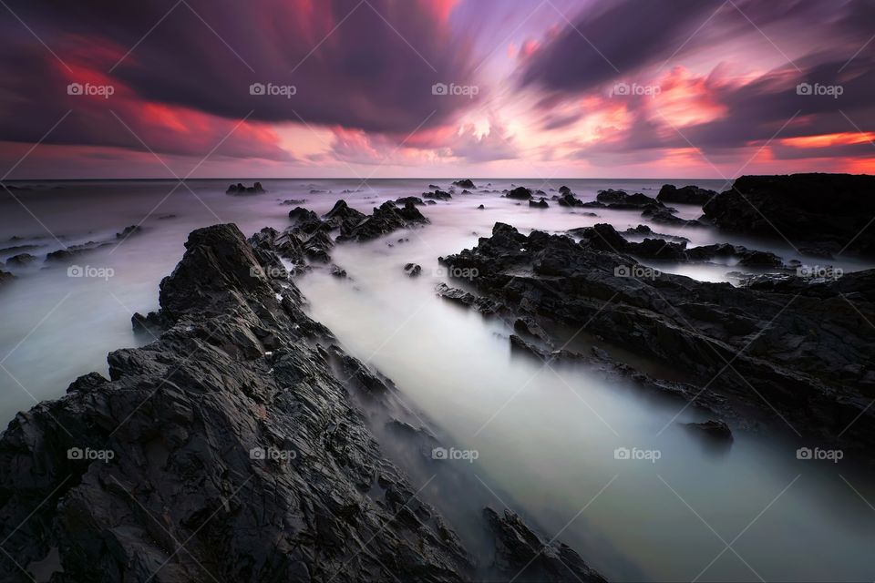 Long exposure seascape with sunset background and dramatic sky