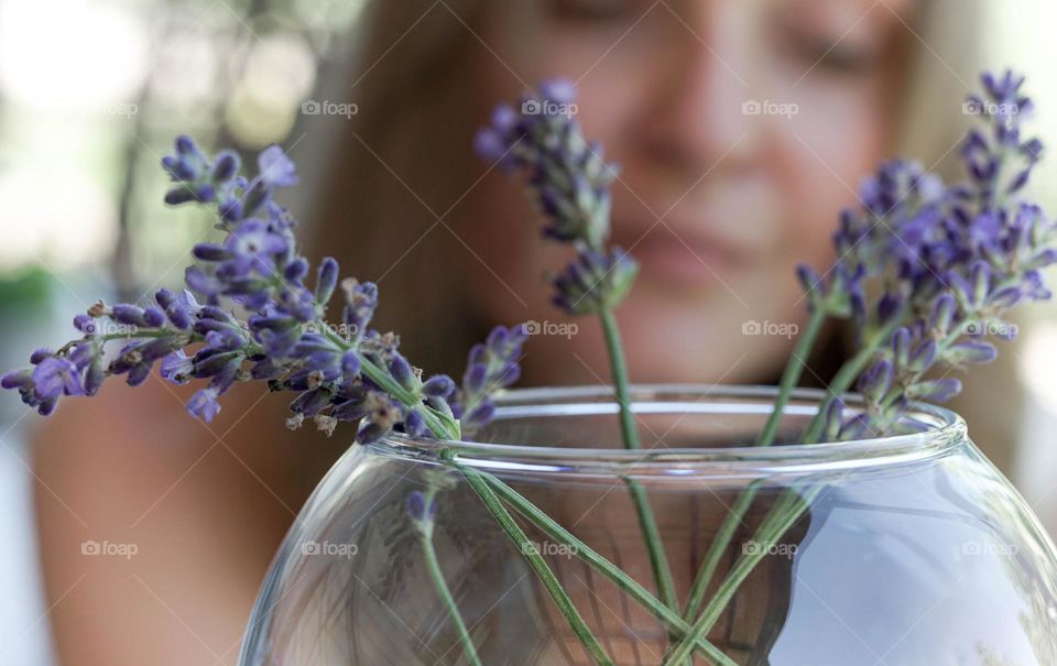 Lavender flowers in a vase, woman’s face, selective focus