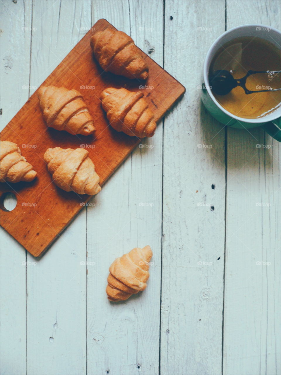 croissants and green tea on white boards