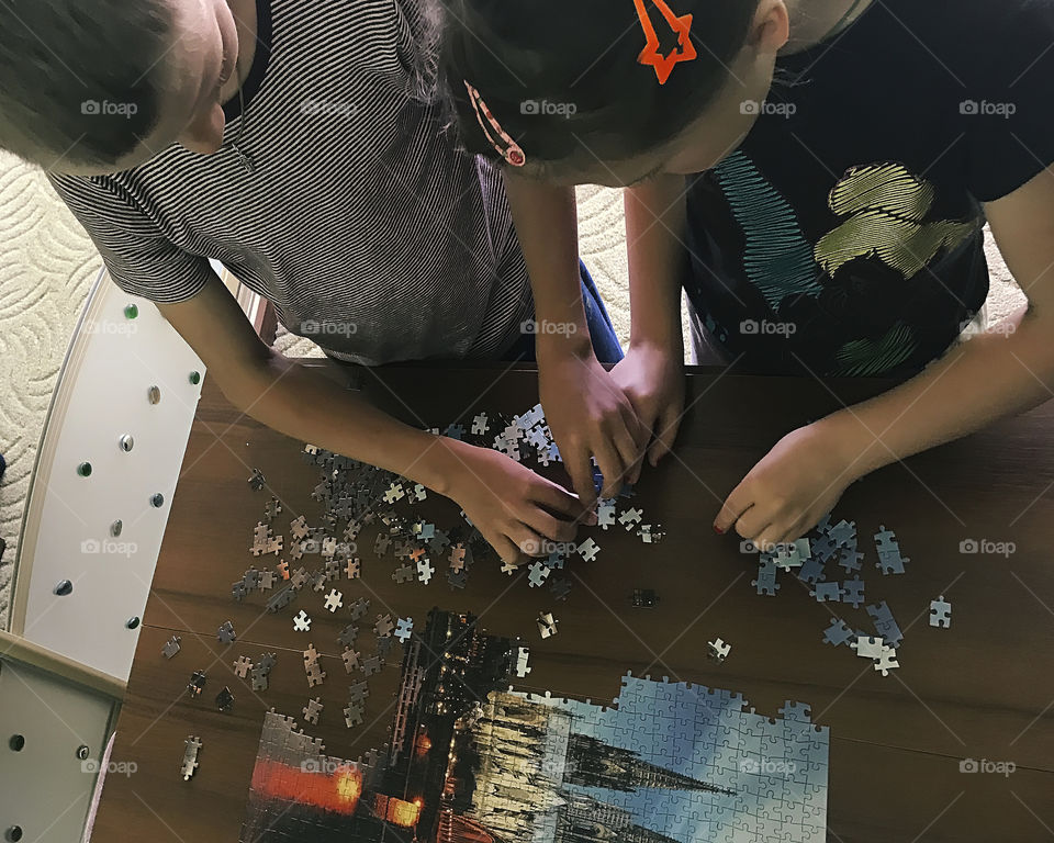 Kids gathering puzzles at home together 