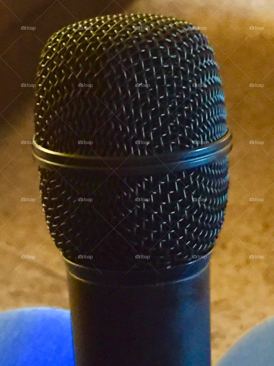 My microphone that I sing with. It is a closeup and it is wireless. It is black with a silver top.