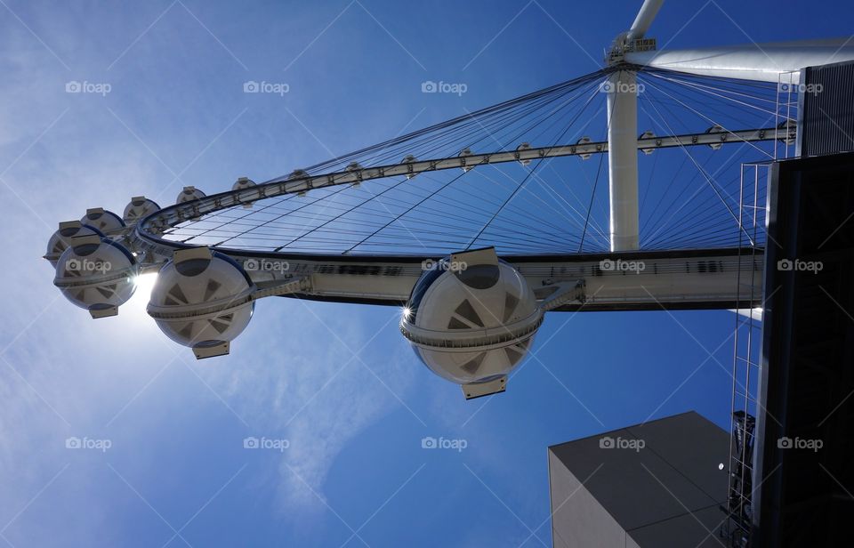 Looking up at the Ferris Wheel. Looking up at the Ferris wheel cars and the sun is peeking through.