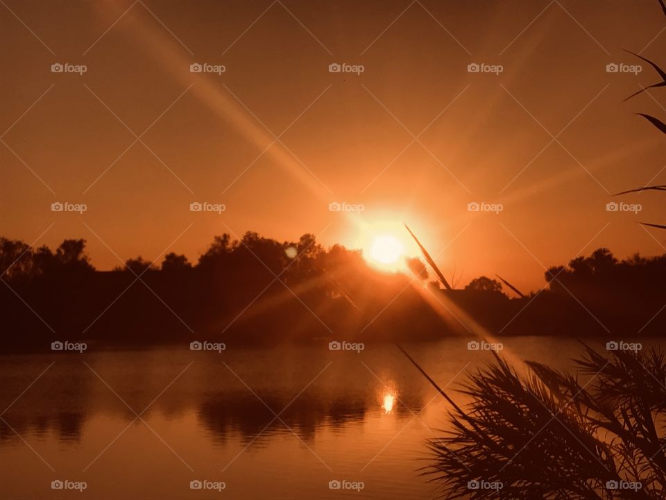 Sundown is near with sunbeams on the front and Faint Sunbeam in backside. Nice added touch calm Lake Water so Peaceful. Hot Summer day coming to close out.