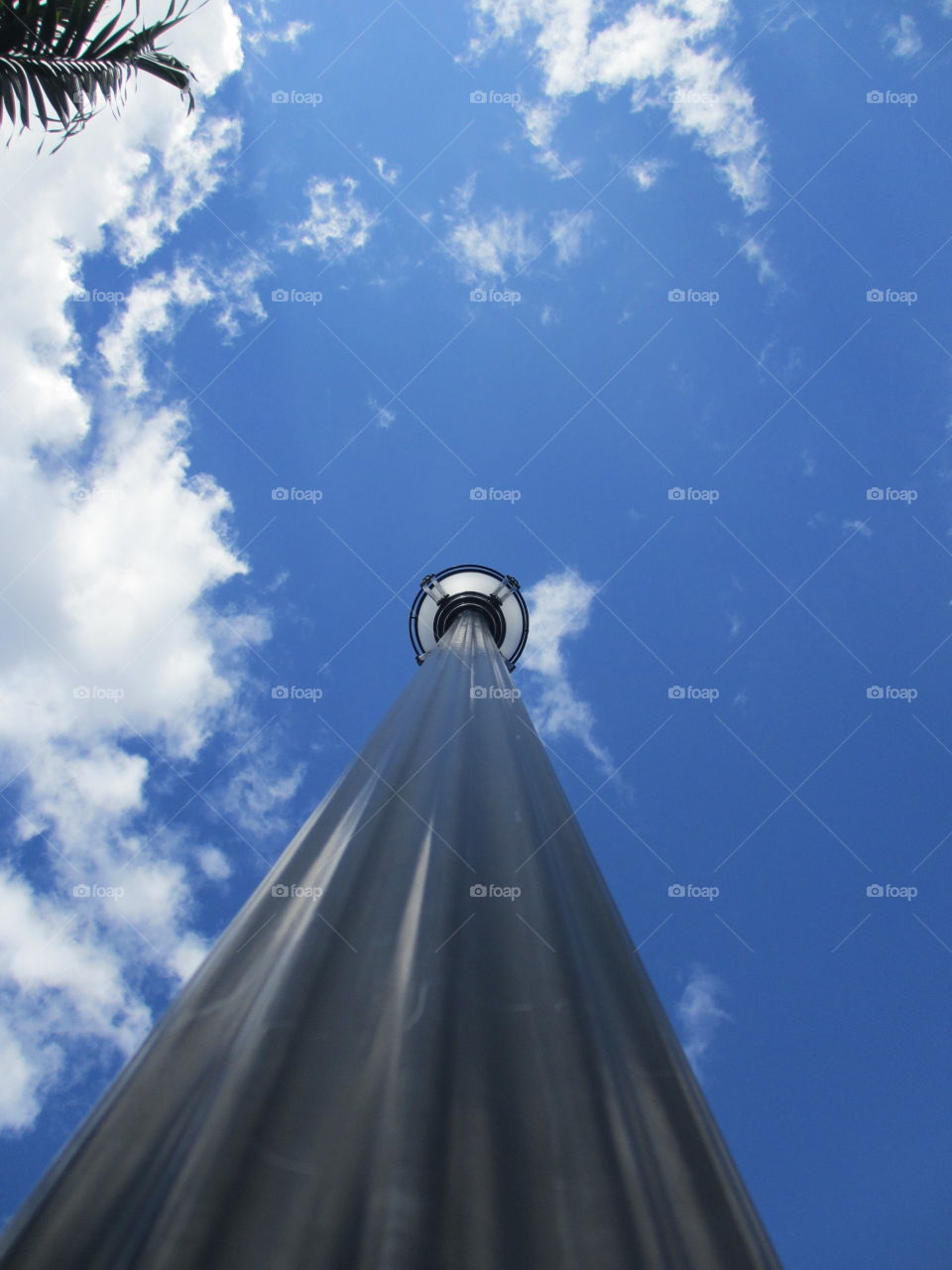 Lamp post against blue sky and clouds