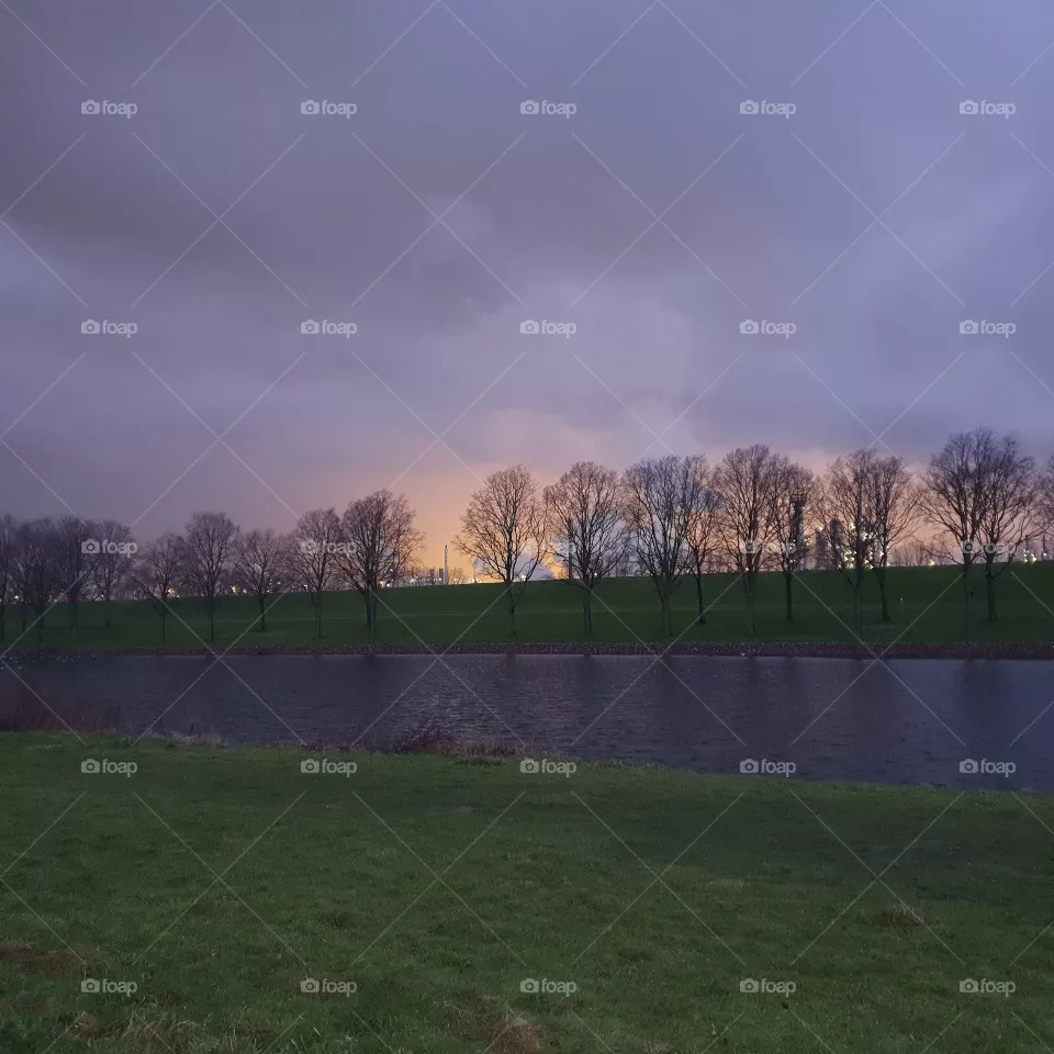 Early evening, sun sets.  light of industry.  the Netherlands